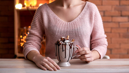 Young woman drinking tasty cacao in cafe