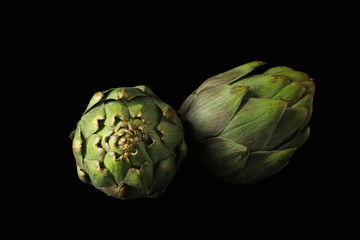 Obraz premium Raw artichokes on black background