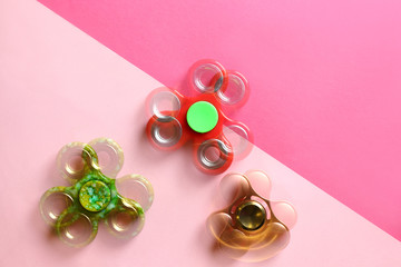 Stroboscopic photo of moving spinners on color background