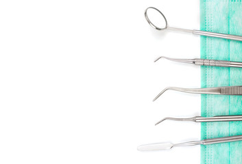Dentist's tools and mask on white background.