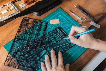 Cutting black plastic vessel model with tools on the cutting board 