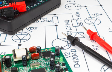 Multimeter probes examining a computer circuit board.