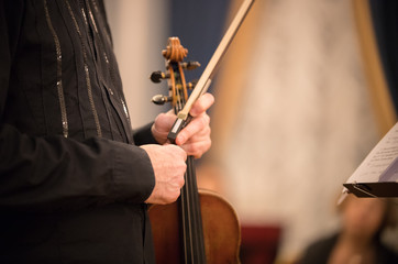 A person holding a violin at the concert