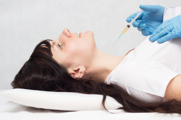 The doctor makes plasma-lifting injection to the girl in the neck against wrinkles and for beautiful skin, plasma therapy