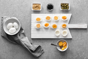 Preparing of tasty deviled eggs on grey table