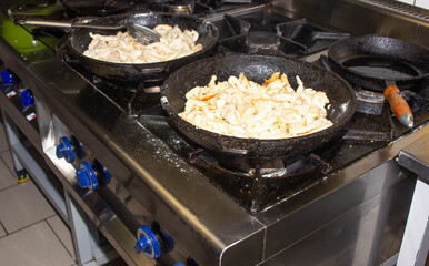 Roasted meat is fried in a griddle for cooking in a restaurant, close-up, eating