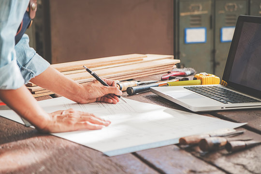 Carpenter working with equipment on wooden table in carpentry shop. woman works in a carpentry shop.