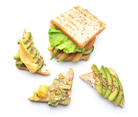 Different tasty sandwiches with avocado on white background