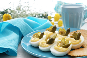 Plate with tasty deviled eggs on table