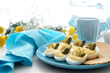 Plate with tasty deviled eggs on table