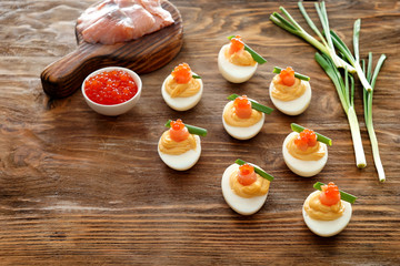 Tasty deviled eggs on wooden table