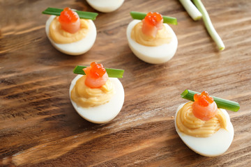Tasty deviled eggs on wooden table