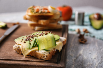 Tasty avocado sandwich on wooden board