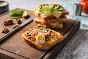 Tasty avocado sandwich on wooden board