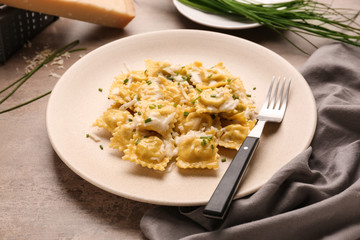 Plate with tasty ravioli on table