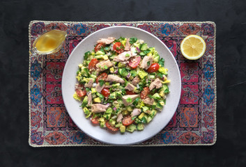 Avocado Tuna Salad in a plate on black table. 