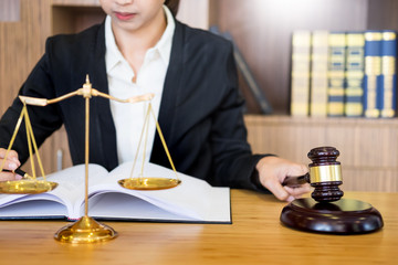 lawyer judge reading documents at desk in courtroom working on wooden desk background. gavel  golden Weight. and soundblock of justice.