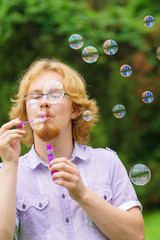 Man blowing soap bubbles, having fun