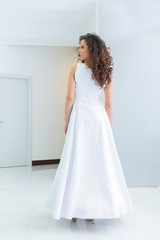 Beautiful young bride with curly hair in white wedding dress