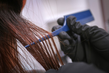 Girl in beauty salon while an hair stylist dyeing her hair