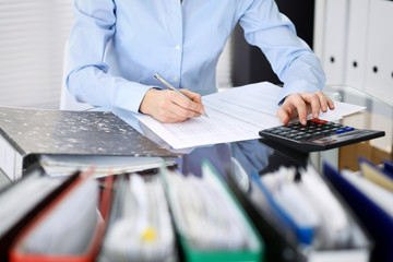 Unknown bookkeeper woman or financial inspector  making report, calculating or checking balance,...