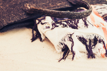 Vintage summer wicker straw beach bag, cover-up beachwear wrap on the sand, tropical background.