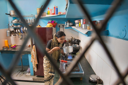 Indian Woman In Kitchen Cooking Food