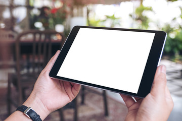 Mockup image of woman's hands holding black tablet pc with blank screen horizontally in cafe