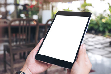 Mockup image of woman's hands holding black tablet pc with blank screen in cafe