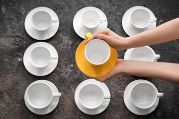 Female hands with tea cups on grunge background