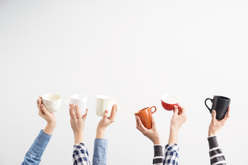 Female hands with tea cups on light background