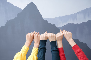 Hands of young women with clenched fists on grey background. Friendship concept