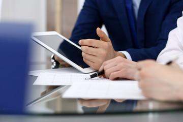 Businessman using laptop at meeting, closeup of hands. Business operations concept