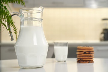 Pitcher and glass of milk, tasty american cookies.