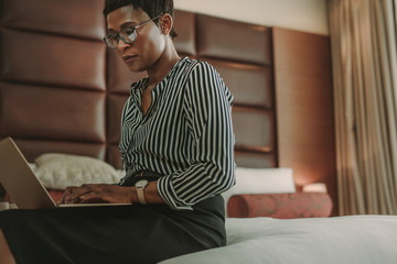 Businesswoman in hotel room working on laptop