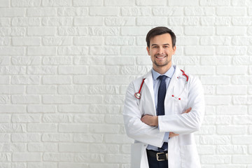 Male pediatrician against white brick wall