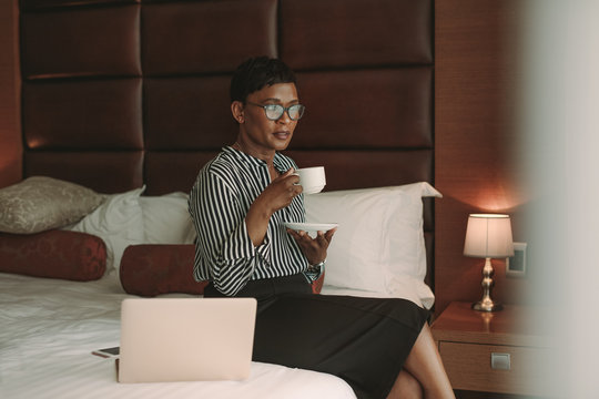 Businesswoman relaxing in hotel room having coffee