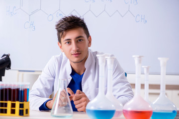 Young chemist sitting in the lab 