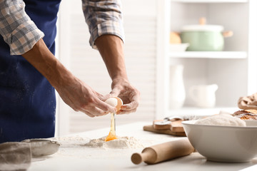 Obraz na płótnie Canvas Young man preparing dough for bread in kitchen