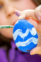Mother and her children paint easter eggs