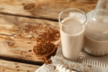 Glass and bottle of tasty buckwheat milk on wooden table
