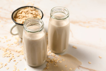 Bottles of tasty oat milk on light table
