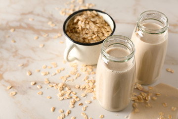 Bottles of tasty oat milk on light table