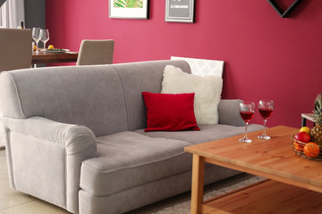 Soft couch with pillows and wooden table in interior of room