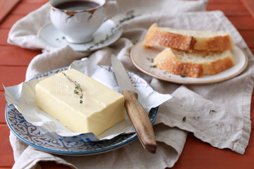 Plate with tasty butter and bread on table