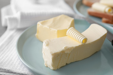 Plate with tasty butter on table
