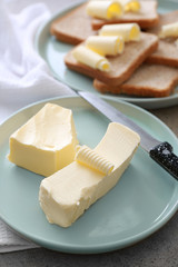 Plate with tasty butter on table