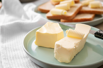 Plate with tasty butter on table