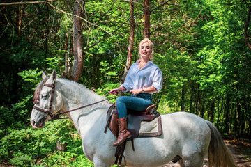 Blonde hair nice woman with horse, rustic style. Spring - summer time . Girl on a farm and nature 