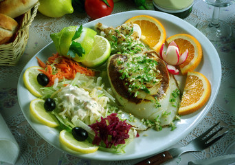 Plato con una sepia a la plancha con ajo y perejil, con una ensalada.